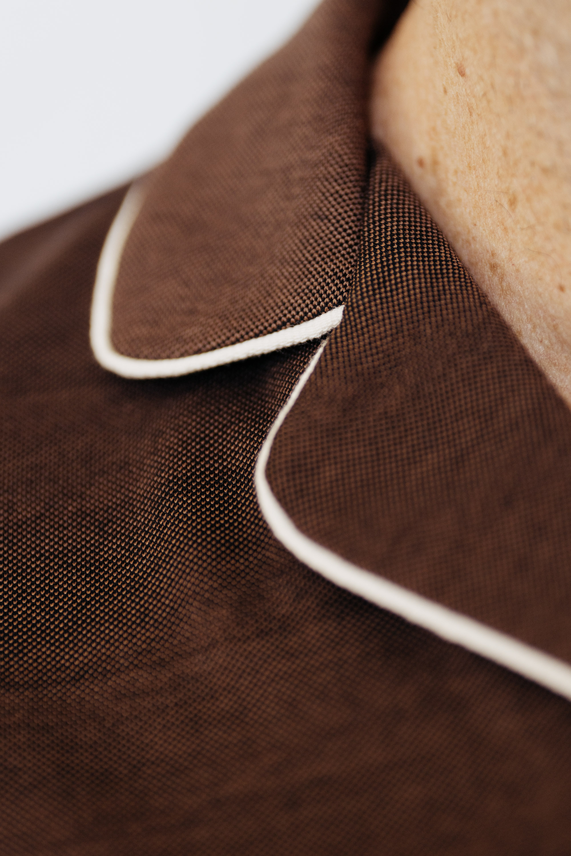 Brown polo shirt collar seamed with withe stripe in retro design